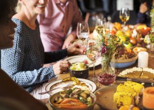 a group of people are gathered around a table set for Thanksgiving